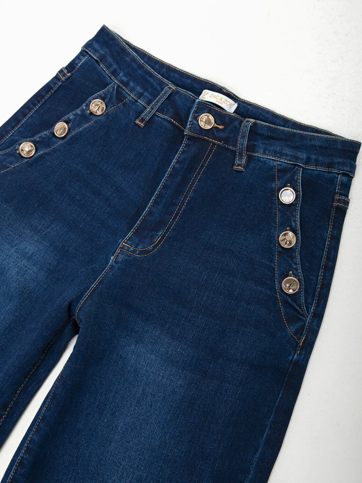 Calças ganga com botões dourados